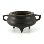 AN ORIENTAL BRONZE CENSER of squat form with triangular handles and triform feet - signed with