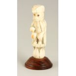 AN EARLY CARVED IVORY FIGURE depicting a Monkey dressed as a Gentleman, possibly from a chess set;