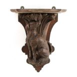 A 19TH CENTURY BLACK FOREST CARVED WALL BRACKET modelled as a seated dog 38.5cm high