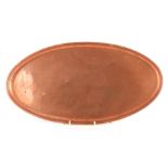 A 1920's KESWICK SCHOOL HAND BEATEN PLAIN OVAL COPPER TRAY with a raised border and stamped Ksia