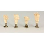 A SET OF FOUR FINELY CARVED IVORY AND NICKLE SEALS modelled as dogs heads, the tallest measuring 6.