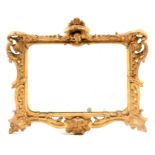 AN 18TH CENTURY CARVED GILTWOOD HANGING MIRROR with leaf work and floral decorated frame above a