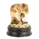 A LATE 19TH CENTURY INDIAN CARVED IVORY SCULPTURE OF A LION AND AN ELEPHANT with gilt and coloured