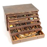 A LARGE COLLECTION OF JEWELERS AND WATCHMAKERS TOOLS contained in a set of pine drawers