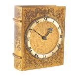 A MID 20TH CENTURY NOVELTY GILT BRASS MANTEL CLOCK modelled as a book with scroll engraved