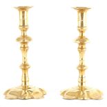 A LARGE PAIR OF GEORGE II SEAMED BRASS PETAL BASE CANDLESTICKS with petal-shaped sconces and bases