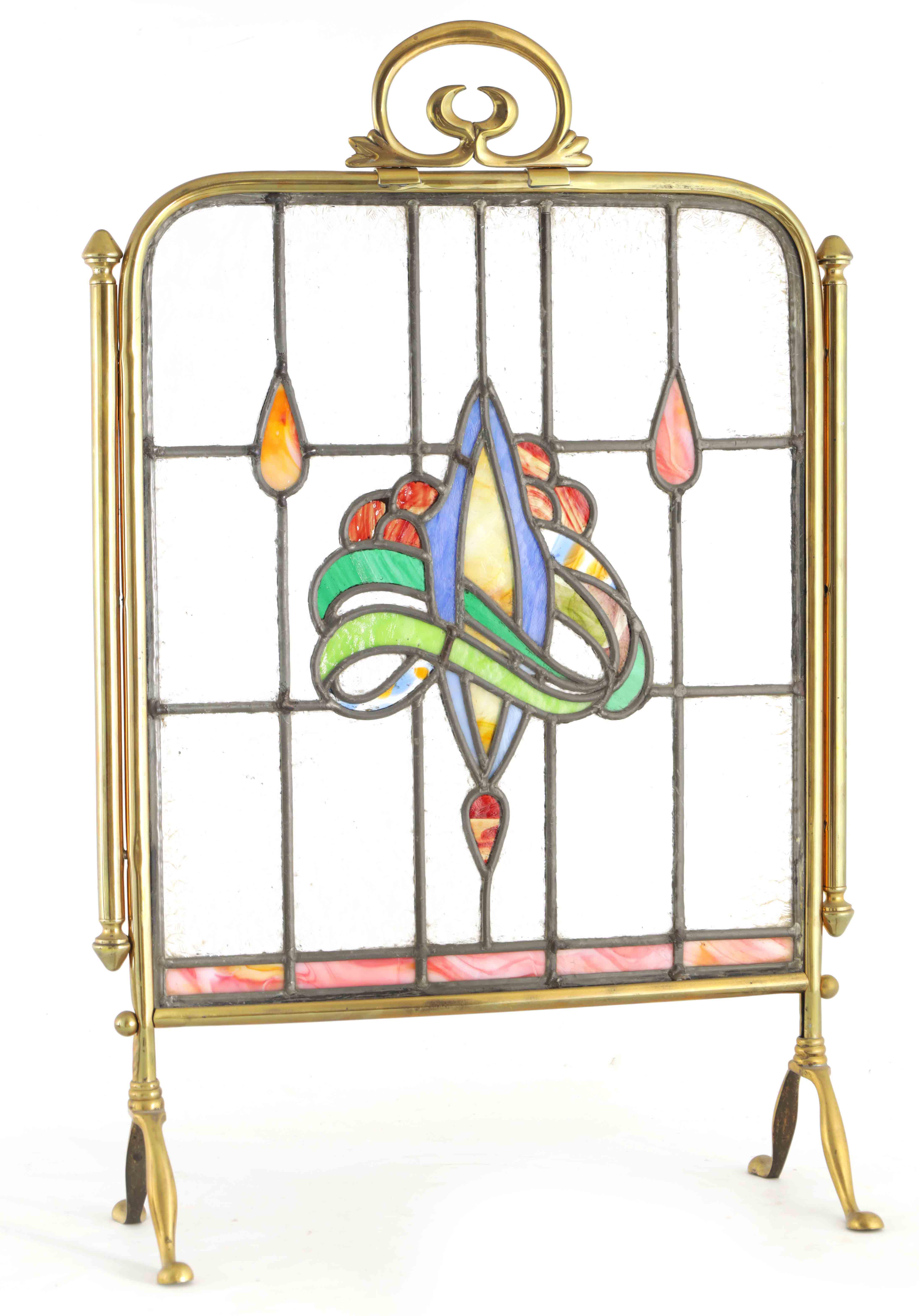 AN ART NOUVEAU BRASS AND STAINED GLASS FIRE SCREEN with coloured leafwork centre surrounded by a