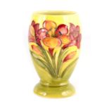 A WALTER MOORCROFT SMALL FOOTED OVOID VASE tube lined and decorated with freesia sprays on a pale