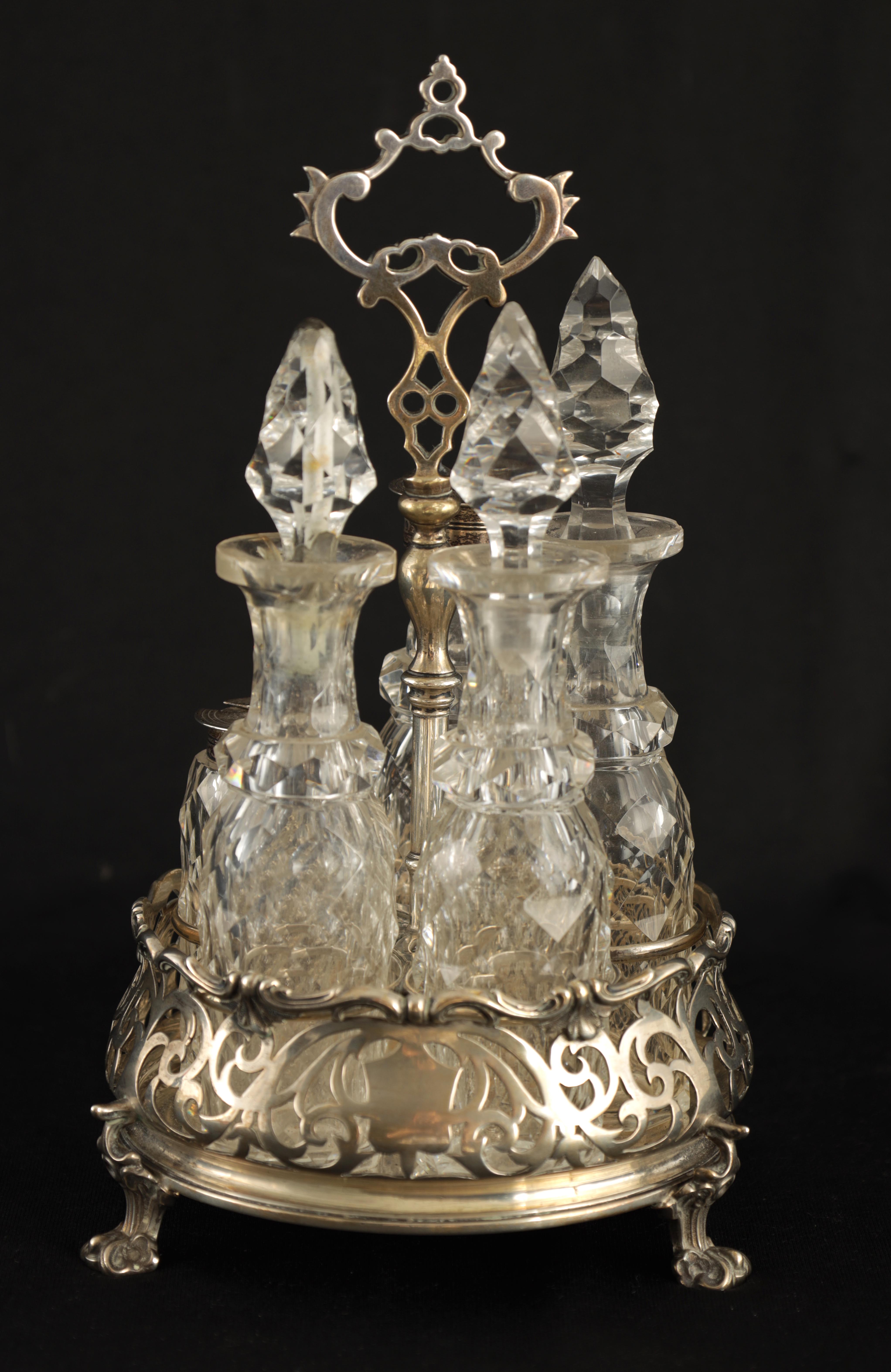 AN EARLY VICTORIAN SILVER 5 BOTTLE CRUET FRAME with shaped pierced handle, turned stem with