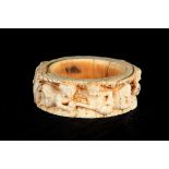 A 17TH/18TH CENTURY INDIAN CARVED IVORY BANGLE intricately carved with figures drinking and