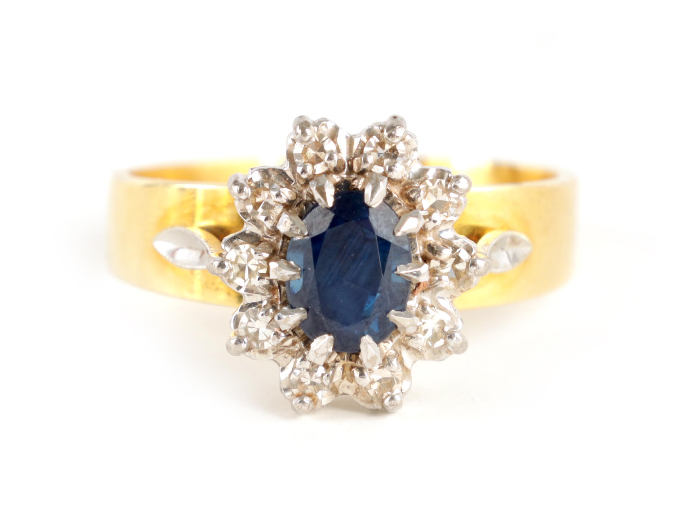 A LADIES 14CT GOLD DIAMOND AND SAPPHIRE RING with oval cut centre stone enclosed by 10 brilliant-cut