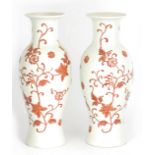 A PAIR OF CHINESE WHITE AND IRON RED VASES of baluster form with floral decoration, seal marks to