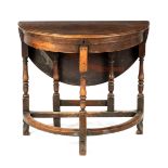 A WILLIAM AND MARY WALNUT D END SIDE TABLE with drop-down leaf and lift up top; standing on ringed