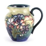 A MOORCROFT SHOULDERED TAPERING JUG tube lined and decorated in the spring flowers pattern on a