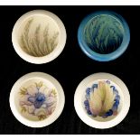 A COLLECTION OF FOUR MOORCROFT CIRCULAR SHALLOW DISHES WITH CURVED RIMS three cream ground with