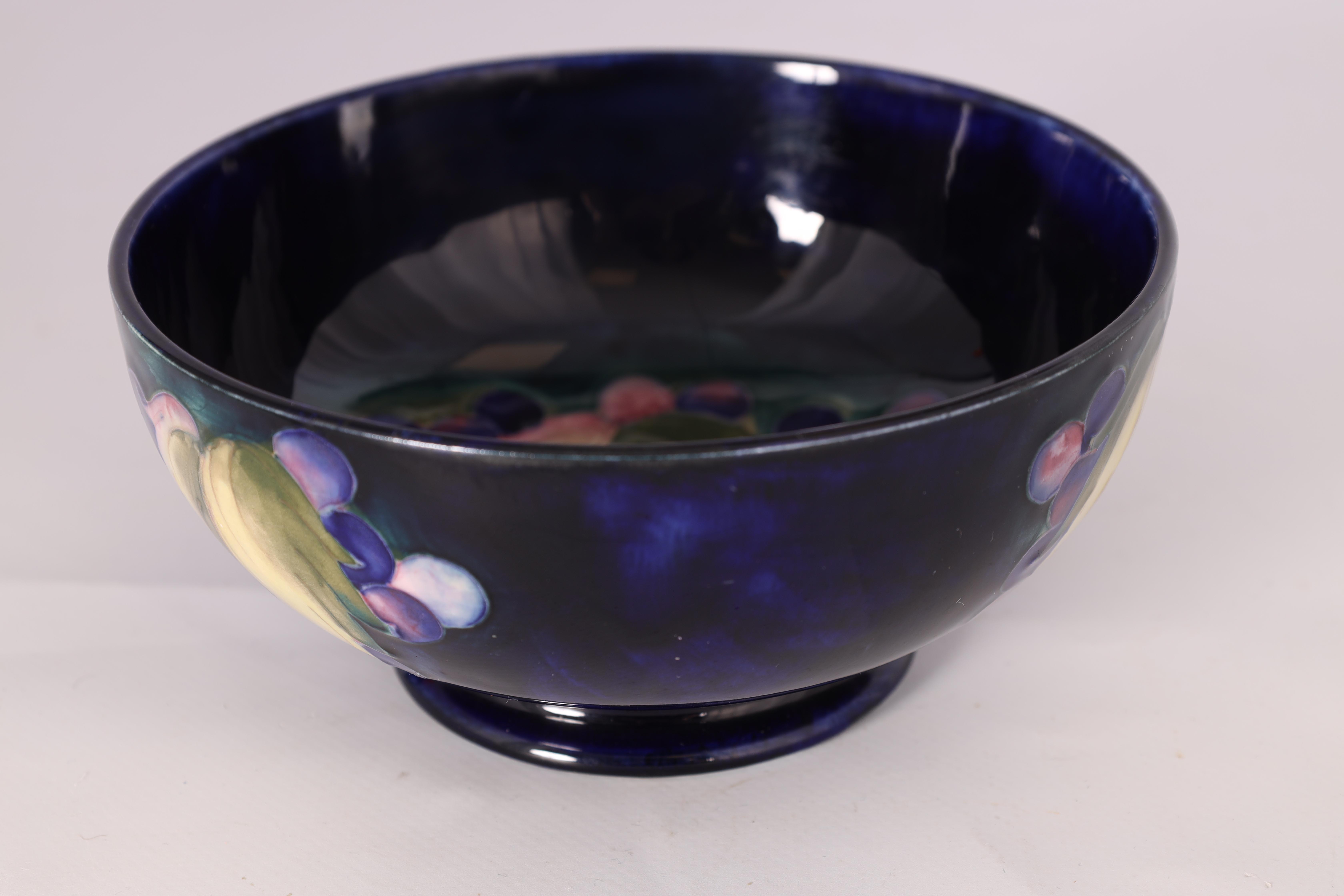 A 1930S MOORCROFT FOOTED BOWL decorated in the Leaf and Berry pattern on a dark mottled blue ground, - Image 3 of 6