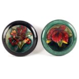 TWO MOORCROFT SHALLOW SMALL DISHES WITH CURVED RIMS decorated with an orchid flowerhead and Spring