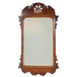 AN 18TH CENTURY WALNUT HANGING MIRROR with scrolled shaped frame enclosing a bevelled mirror plate