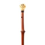 A LATE 19TH CENTURY IVORY HANDLED WALKING CANE the handle finely modelled as a clenched fist holding