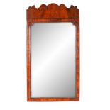 A QUEEN ANNE WALNUT LONG HANGING MIRROR with shaped cross-grain moulded border beneath a scalloped