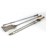 A SET OF REGENCY STEEL AND BRASS FIRE IRONS with cast brass handles and barley twist stems, the