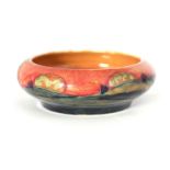 A MOORCROFT SMALL CIRCULAR BOWL WITH FOLDED RIM decorated in the Eventide pattern on a mottled