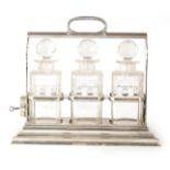 A 19TH CENTURY WALKER AND HALL SILVER PLATED THREE BOTTLE TANTALUS with hold fast locking device and