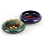 TWO MOORCROFT SHALLOW SMALL DISHES WITH CURVED RIMS decorated with flower head sprays on a dark