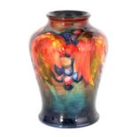 A 1930S MOORCROFT TAPERING SHOULDERED VASE decorated in the Autumn leaf and Berry pattern, on a