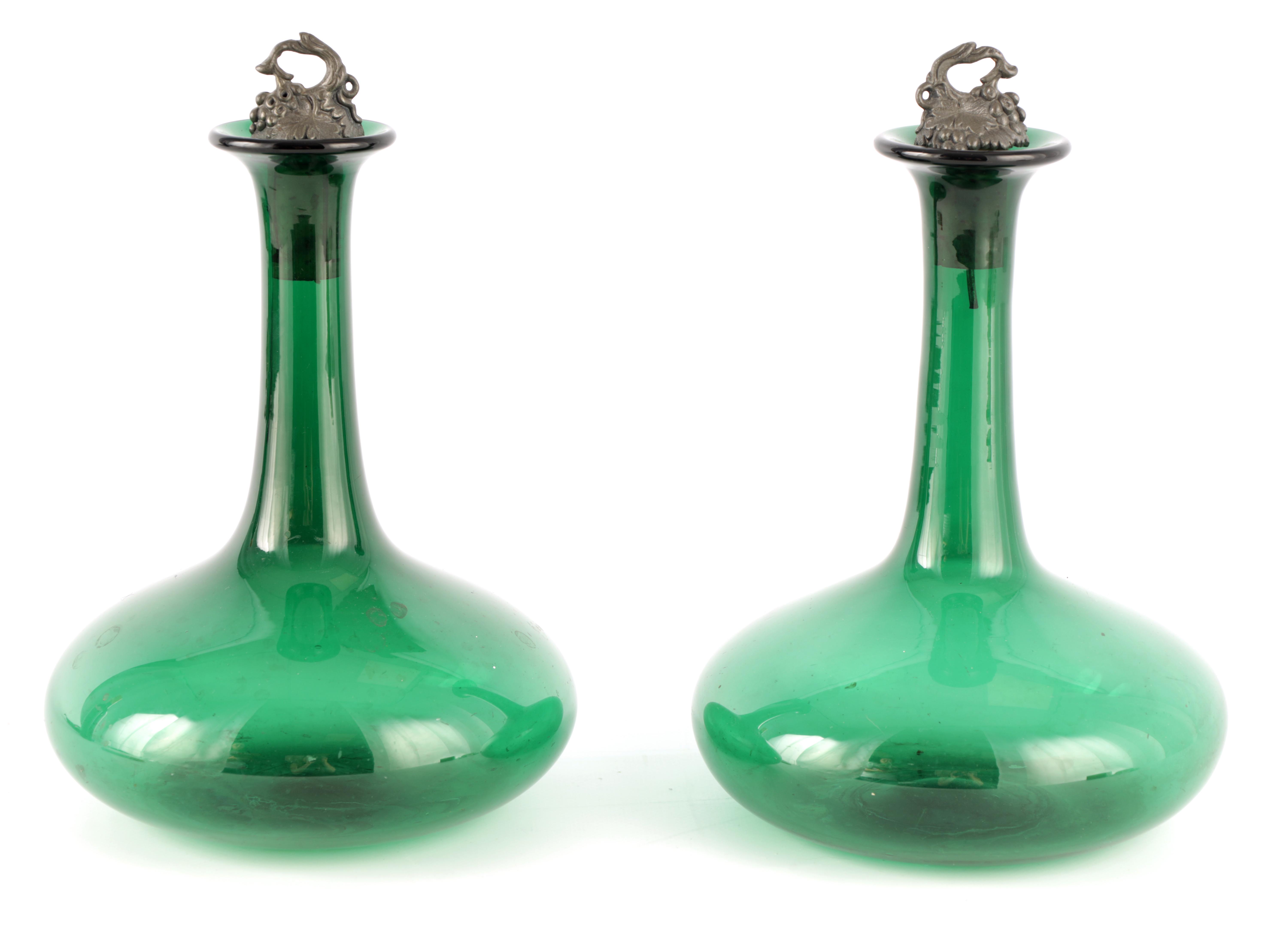 A PAIR OF LATE GEORGIAN BRISTOL GREEN DECANTERS with heavy bulbous bases and pewter grape vine
