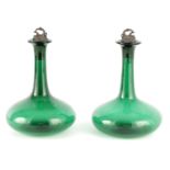 A PAIR OF LATE GEORGIAN BRISTOL GREEN DECANTERS with heavy bulbous bases and pewter grape vine