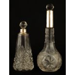 TWO 19TH CENTURY SILVER TOPPED CUT GLASS PERFUME BOTTLES with faceted stoppers 18cm and 13cm high