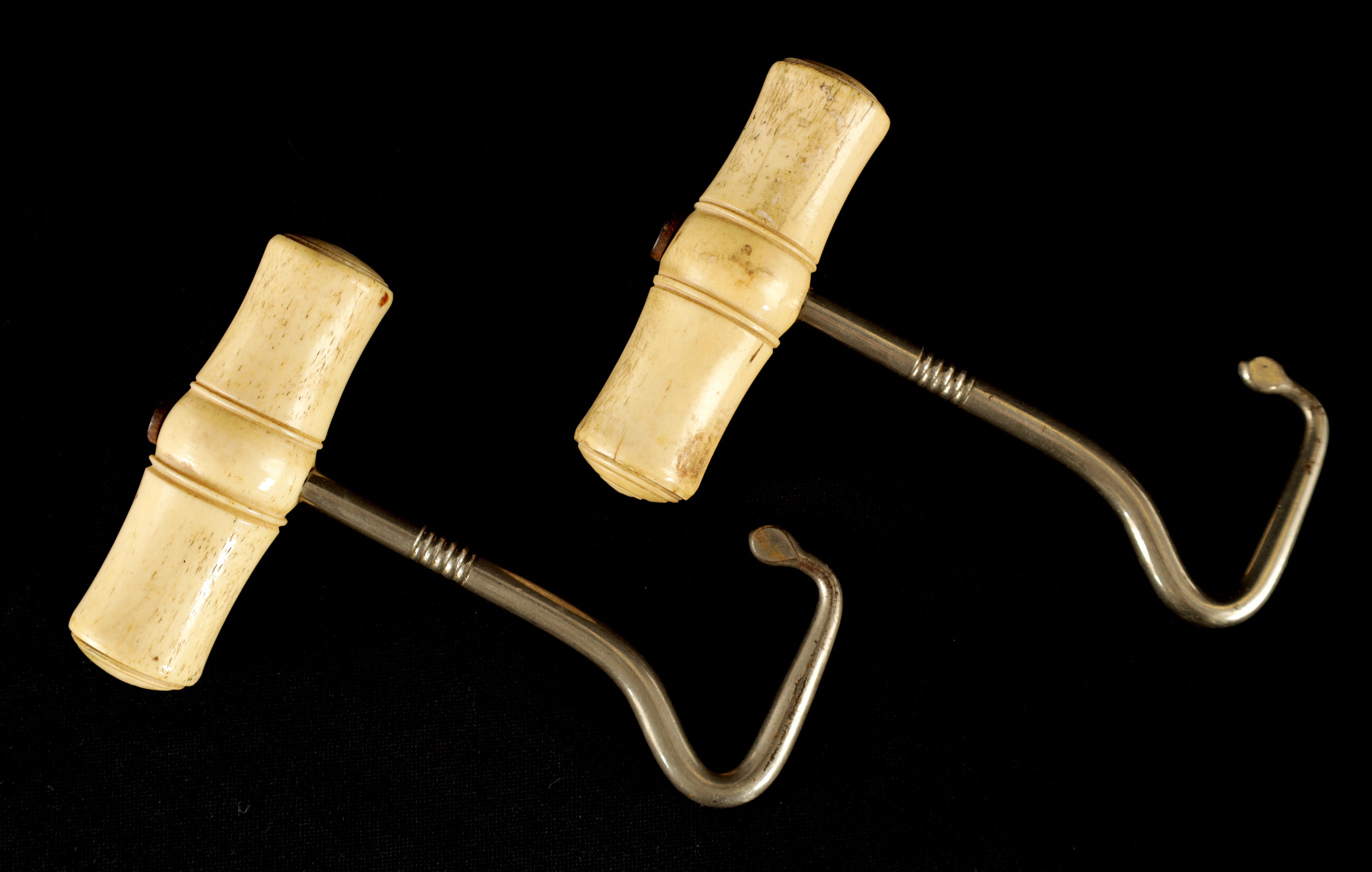 A PAIR OF LATE 19TH CENTURY BONE AND SILVERED METAL BOOTJACKS with turned handles 12.5cm overall