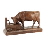 A LATE 19TH CENTURY SWISS BLACK FOREST CARVED WALNUT SCULPTURE modelled as a cow drinking from a