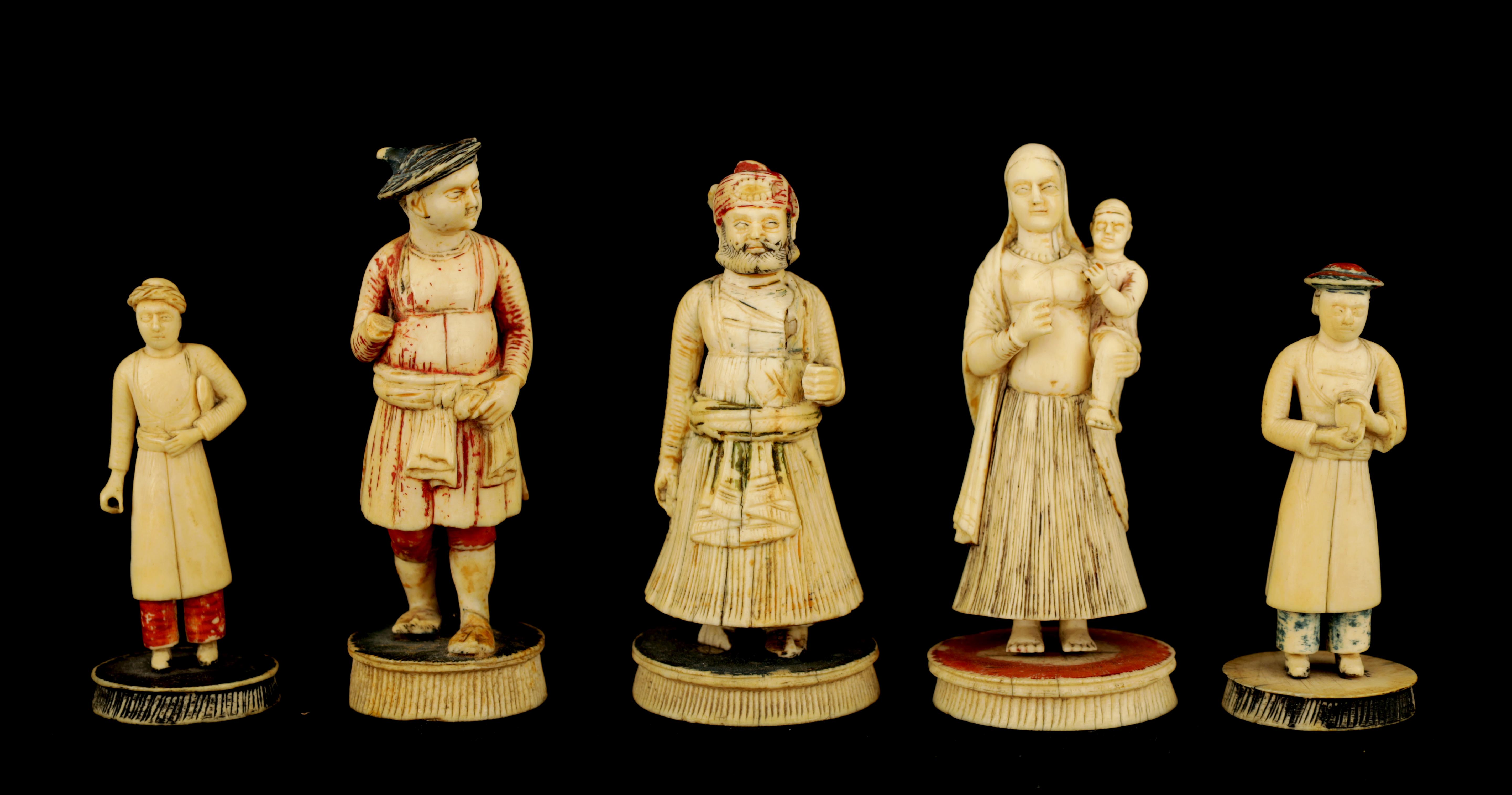 FIVE 19TH CENTURY INDIAN IVORY CHESS PIECES depicting finely carved figures in ceremonial dress