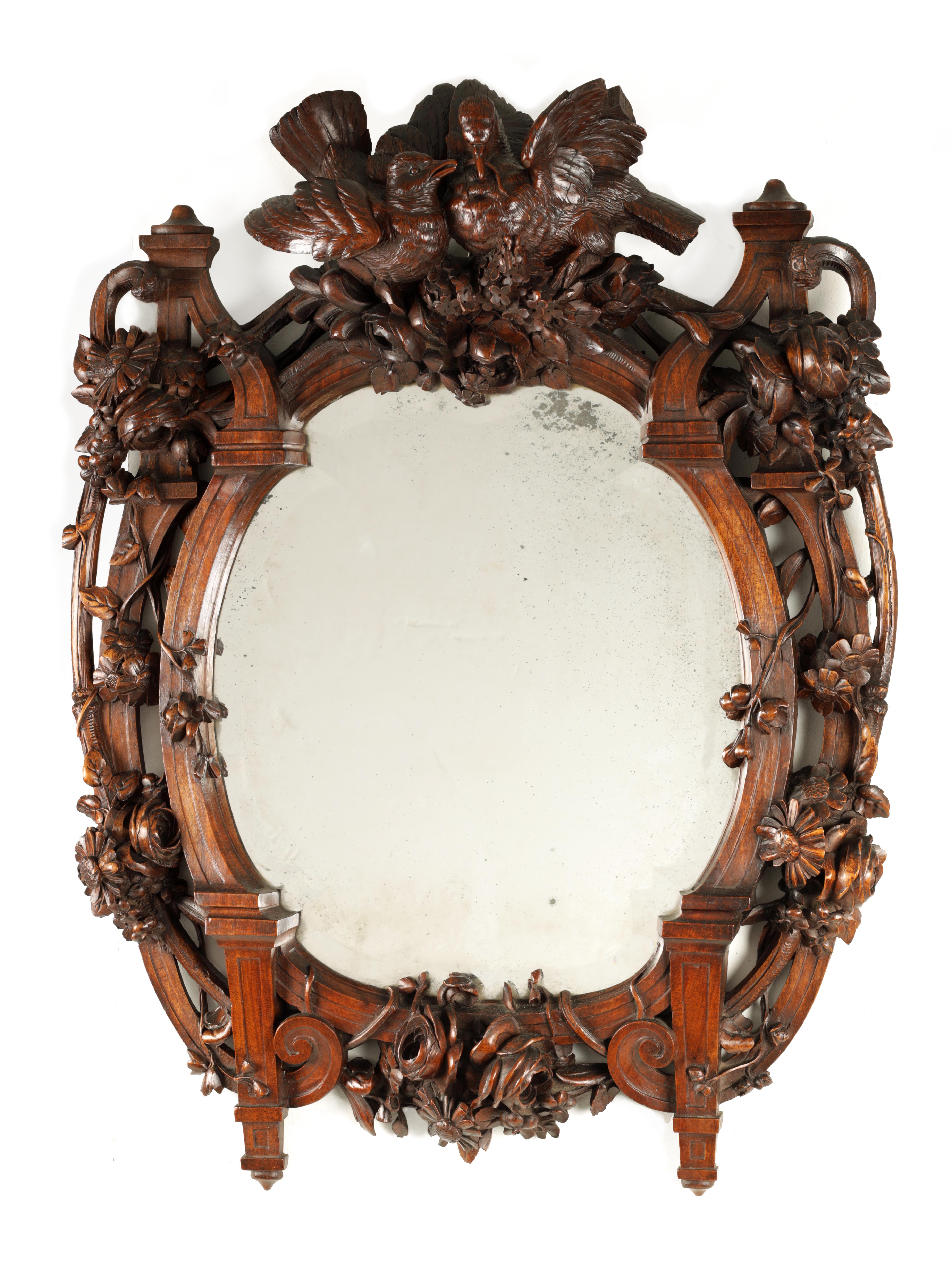 A 19TH CENTURY WALNUT BLACK FOREST CARVED HANGING MIRROR with a pair of doves to the top and a