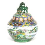 A LARGE CHINESE FAMILLE VERT LIDDED JAR surmounted by a foo dog finial on a domed lid with panels to