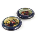 TWO MOORCROFT SHALLOW SMALL DISHES WITH CURVED RIMS decorated with sprays of spring flowers on a