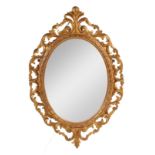 A GOOD EARLY 19TH CENTURY CARVED GILTWOOD OVAL HANGING MIRROR with leaf carved pierced frame
