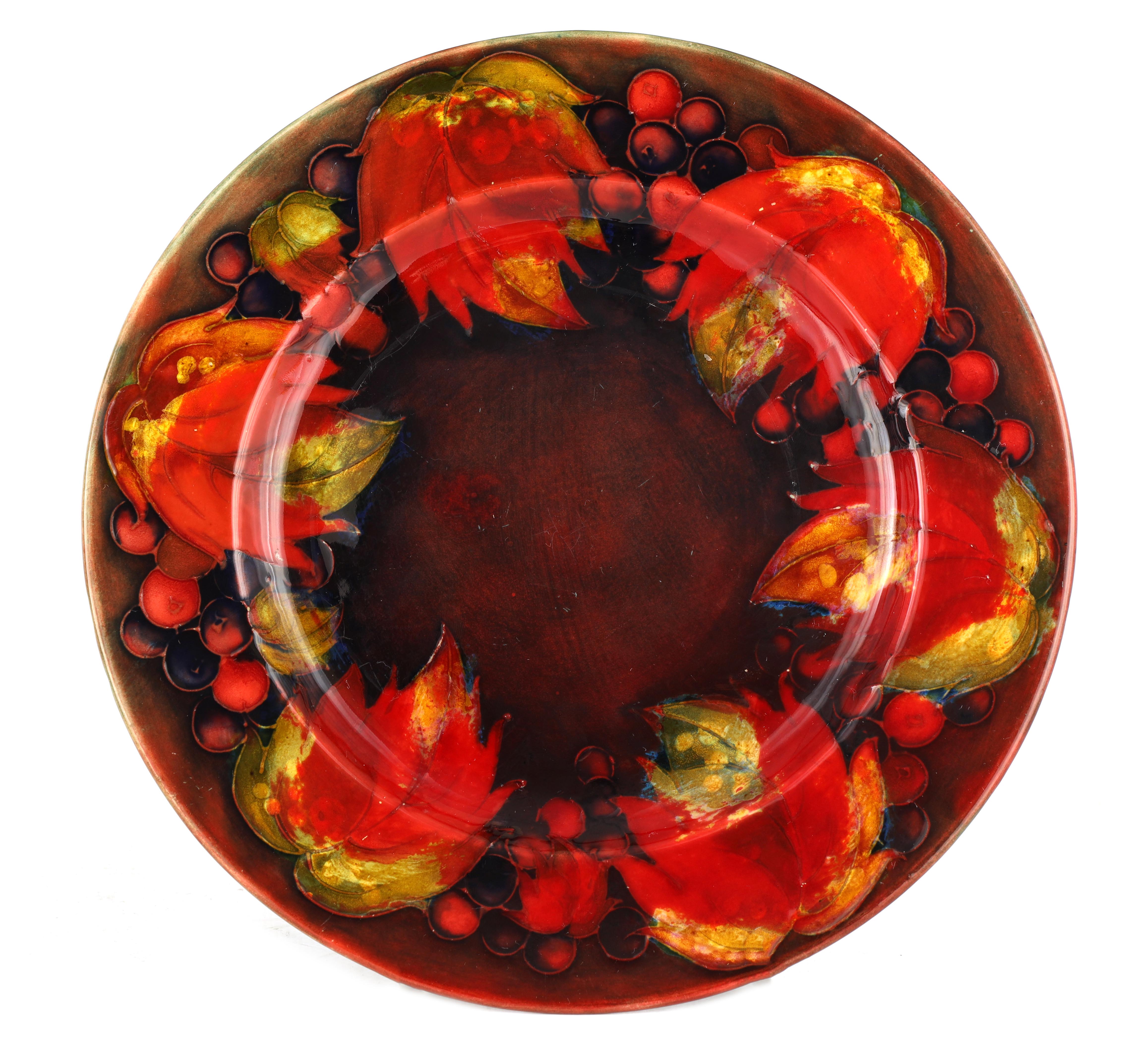 A 1930S MOORCROFT AUTUMN LEAF AND BERRY PATTERN FLAMBE PLATE 24cm diameter, impressed signature mark