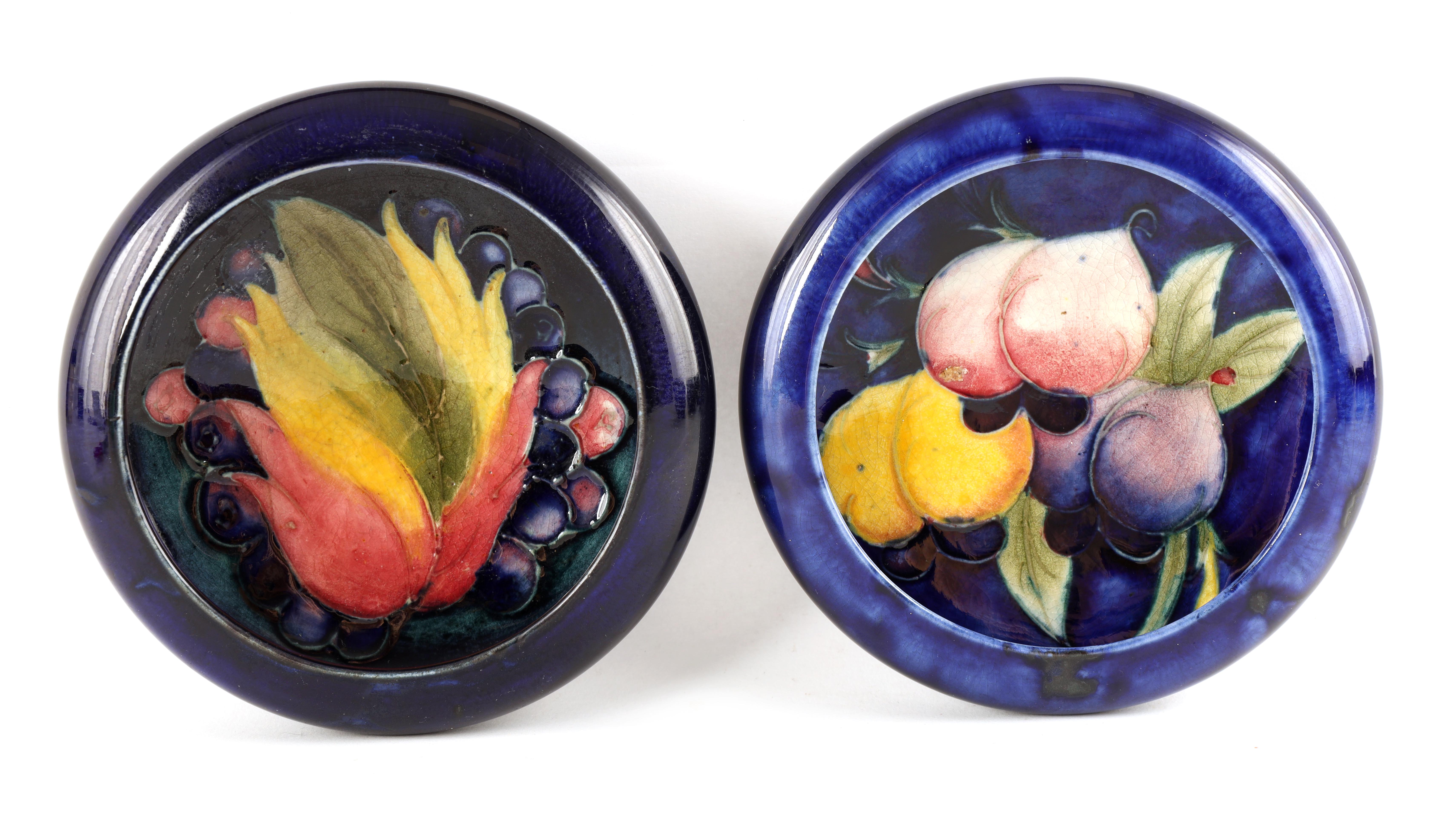 TWO MOORCROFT SHALLOW SMALL DISHES WITH CURVED RIMS decorated in the Leaf and Berry and Plum pattern