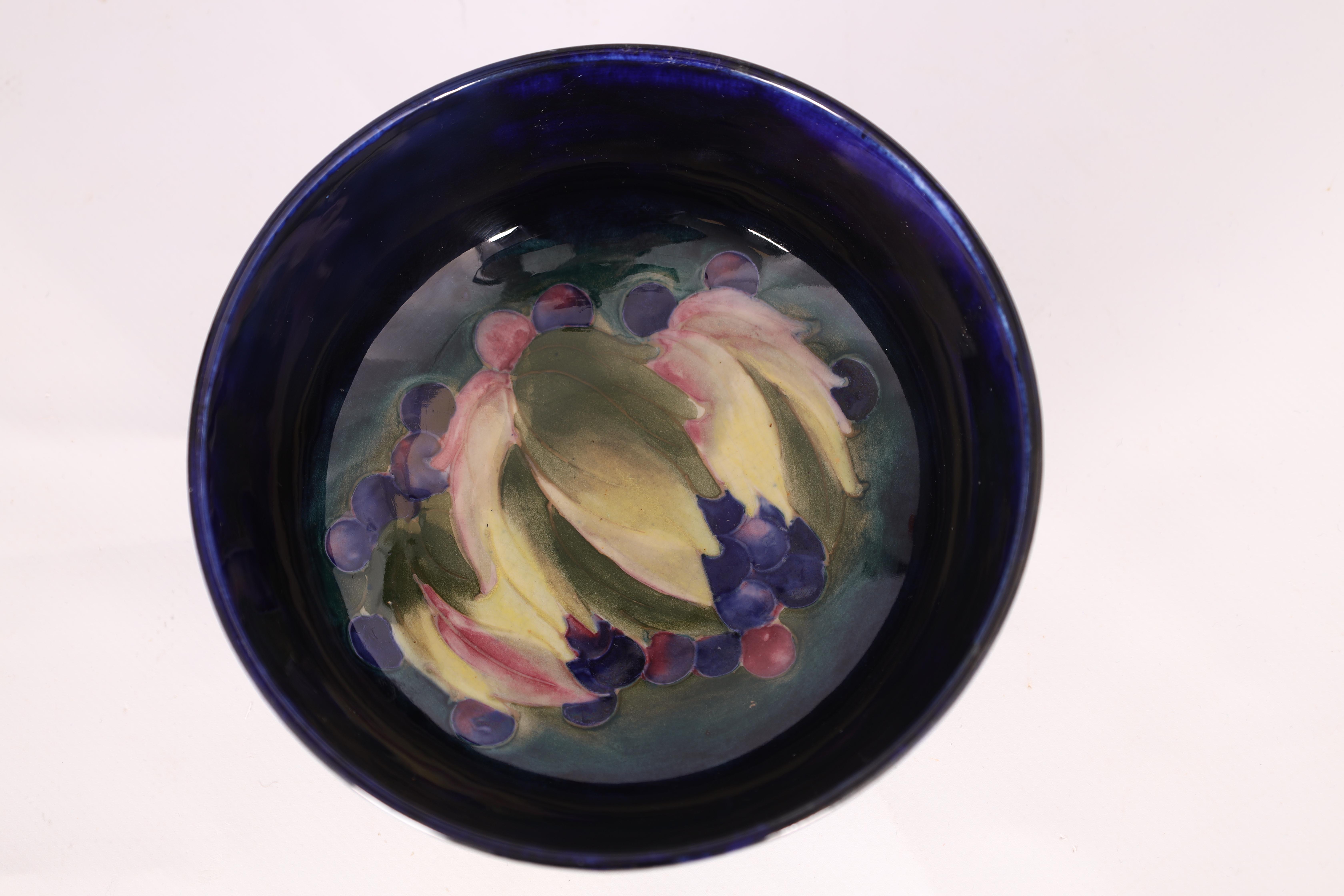 A 1930S MOORCROFT FOOTED BOWL decorated in the Leaf and Berry pattern on a dark mottled blue ground, - Image 5 of 6