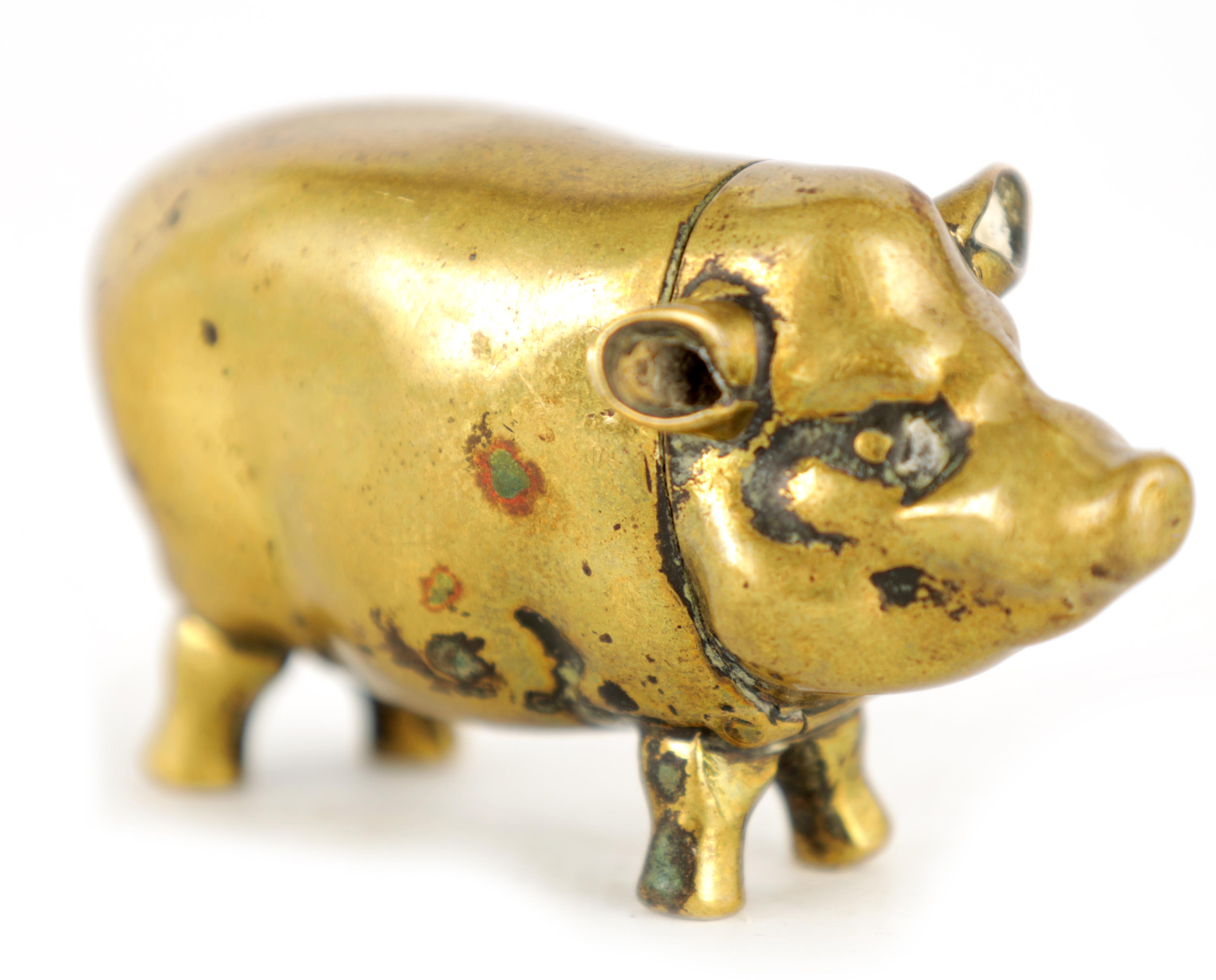 A 19TH CENTURY BRASS VESTA CASE FORMED AS A PIG with hinged head and striker to the belly 6cm wide