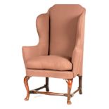 A QUEEN ANNE WALNUT WING-BACK UPHOLSTERED ARMCHAIR having shaped headrests and cushion seat;