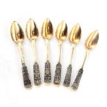 A SET OF SIX RUSSIAN SILVER GILT NIELLO TEASPOONS with shaped handles decorated with blackened