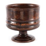 A LARGE 19TH CENTURY TURNED ELM WASSAIL BOWL with banded decoration raised on a turned moulded