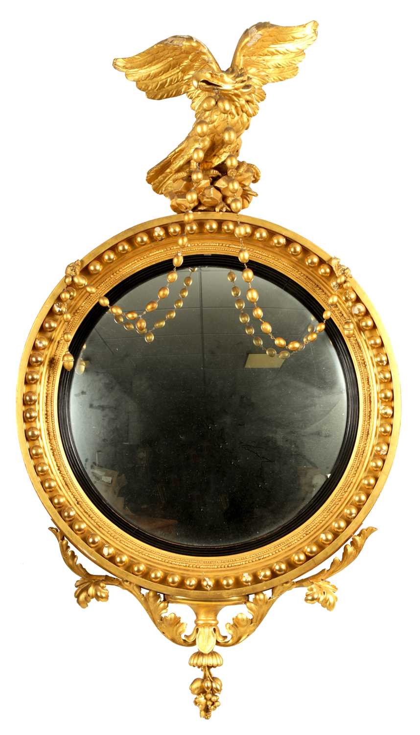 A REGENCY CARVED GILTWOOD CONVEX MIRROR OF LARGE SIZE