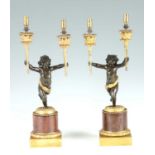 A PAIR OF FRENCH PATINATED BRONZE, ORMOLU AND ROUGE MARBLE FIGURAL CANDELABRA