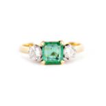 A LADIES 18CT GOLD THREE STONE EMERALD AND DIAMOND RING