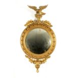 A REGENCY CARVED GILTWOOD CONVEX MIRROR